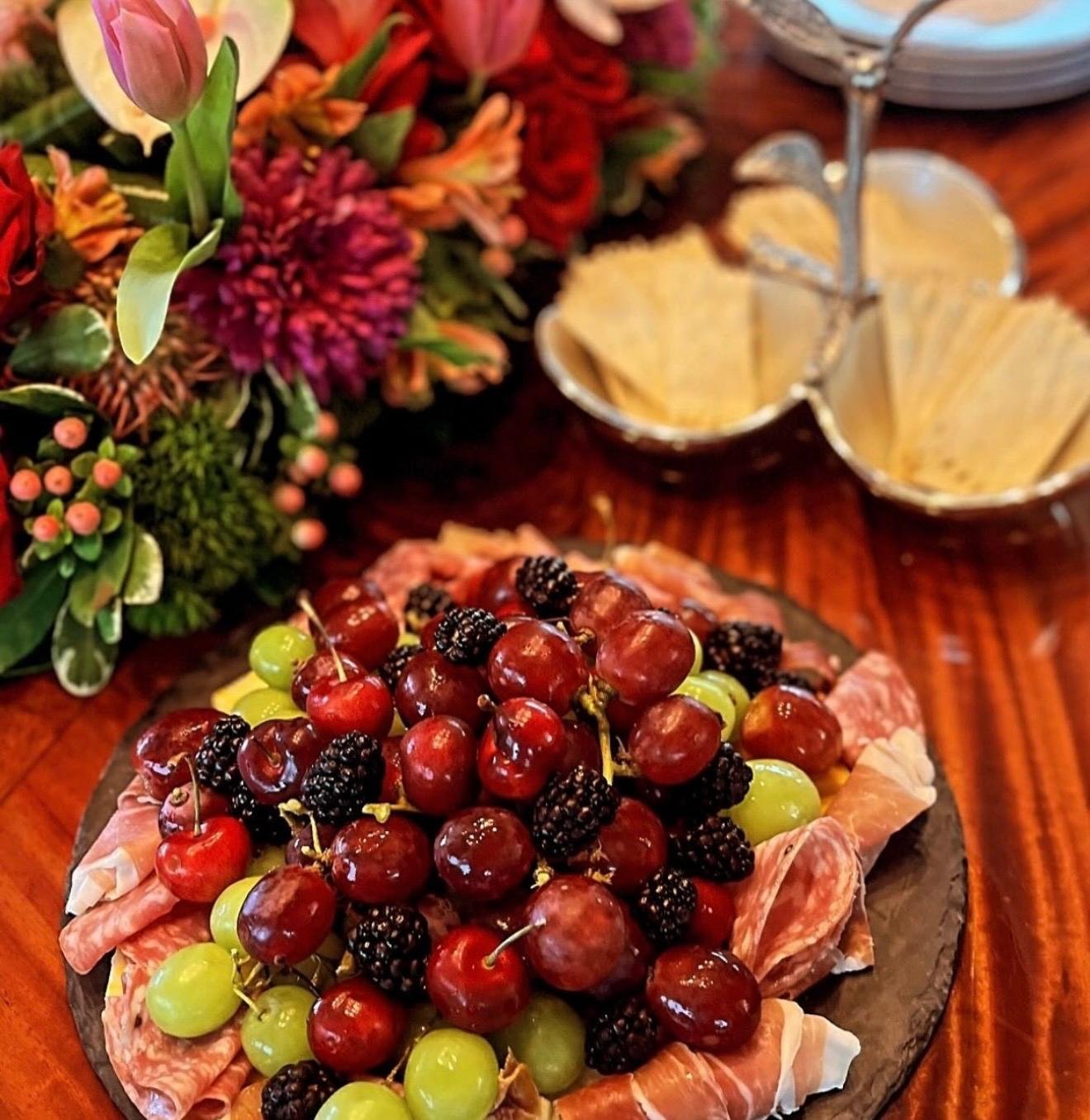 Charcuterie board with grapes, cherries and blackberries
